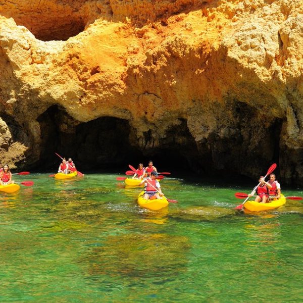 several yellow kayaks with people riding them