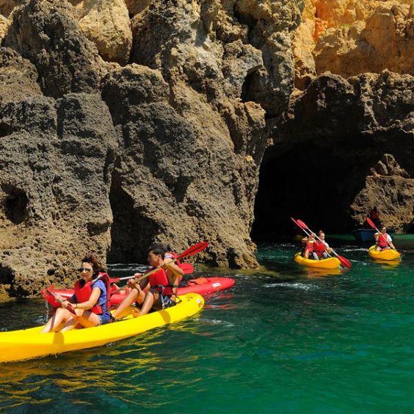 three yellow kayaks with people on them riding
